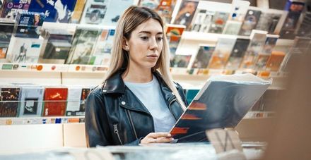 Una mujer está leyendo una revista en una librería.