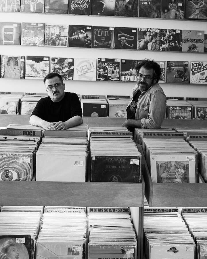 Una fotografía en blanco y negro de dos hombres en una tienda de discos.