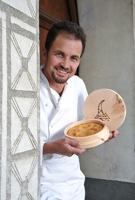 Bäcker zeigt Nusstorte der Giacometti AG