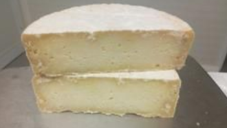 Deux blocs empilés de gâteau ou de fromage jaune pâle sur un plateau métallique.