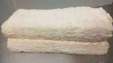 Empilement de deux couvertures blanches moelleuses pliées sur une surface grise