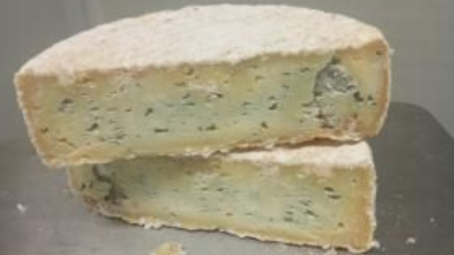 Deux tranches de gâteau pâle à la garniture bleue, empilées sur une surface métallique