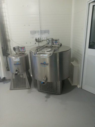 Cuves de brassage en acier inoxydable dans une buanderie blanche près d'une porte