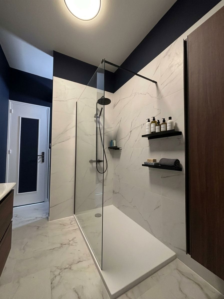 Salle de bains moderne avec cabine de douche en verre, murs en marbre blanc et meubles en bois foncé