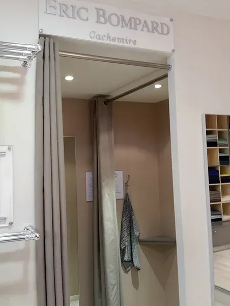 Cabine d’essayage de boutique avec le rideau ouvert