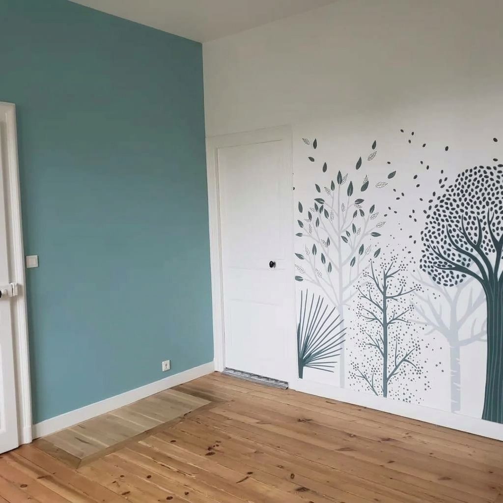 Pièce vide avec un mur d’accent bleu sarcelle, un parquet et une fresque murale 