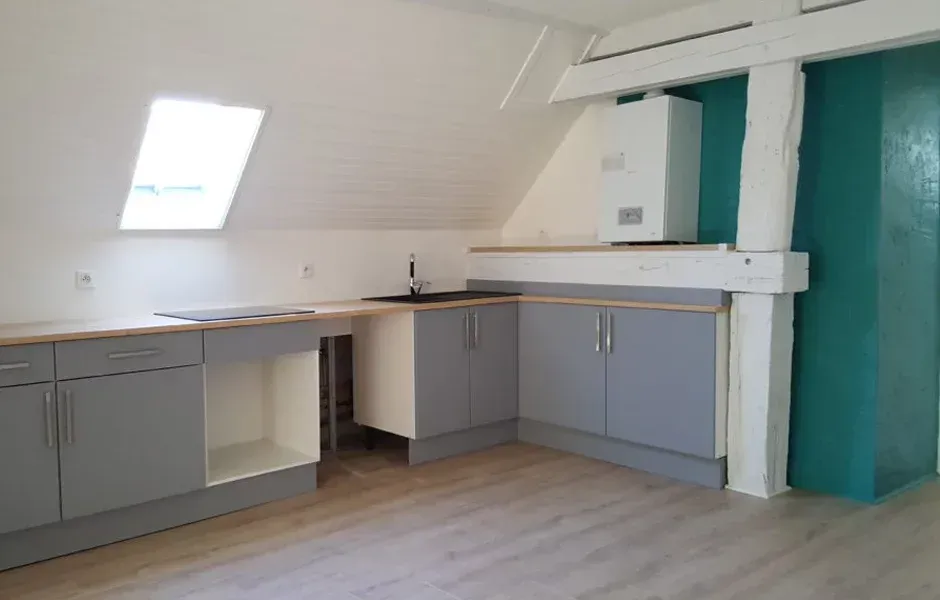 Cuisine moderne avec des placards gris, des plans de travail en bois, une fenêtre de toit 