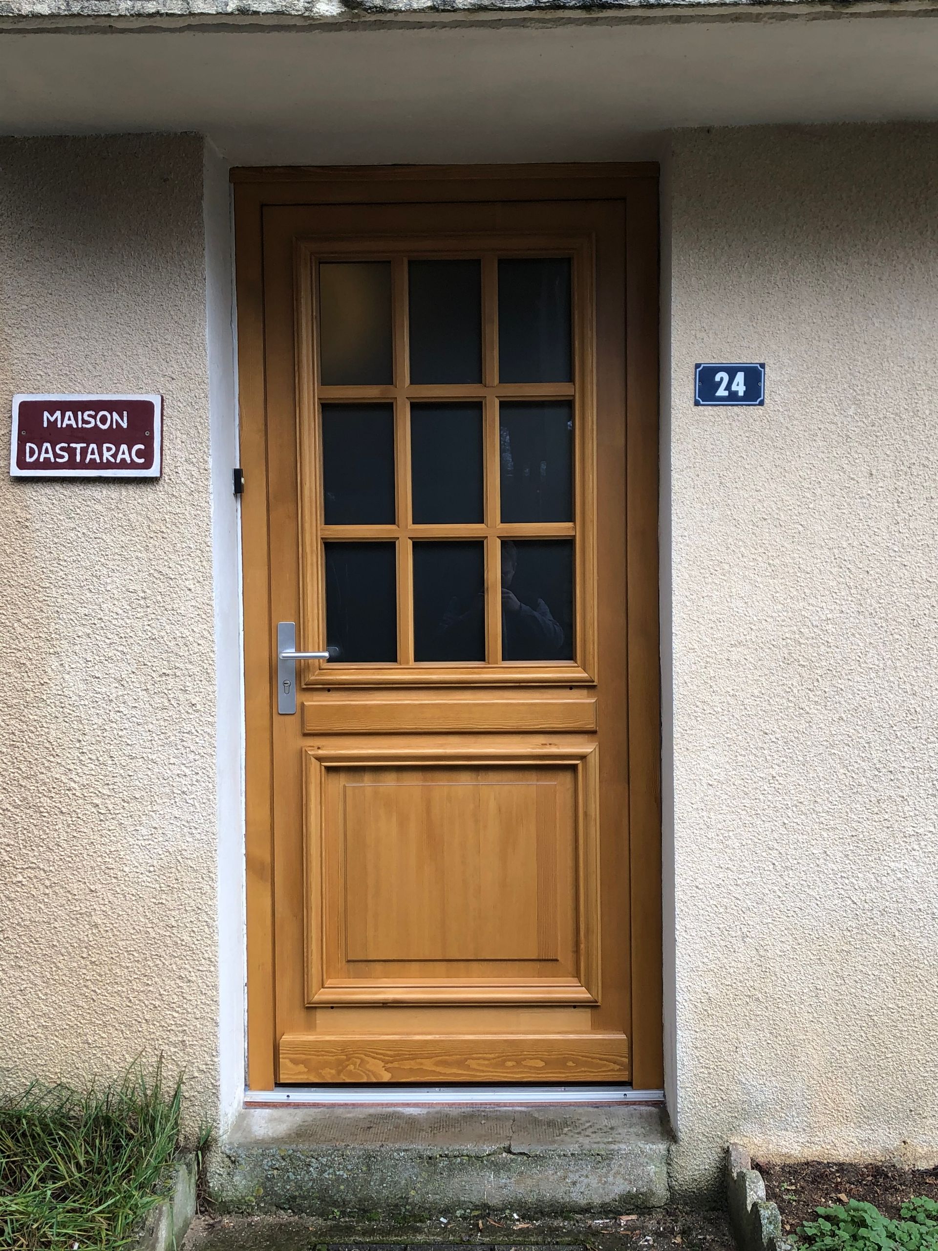 Porte d'entrée en bois avec une partie vitrée