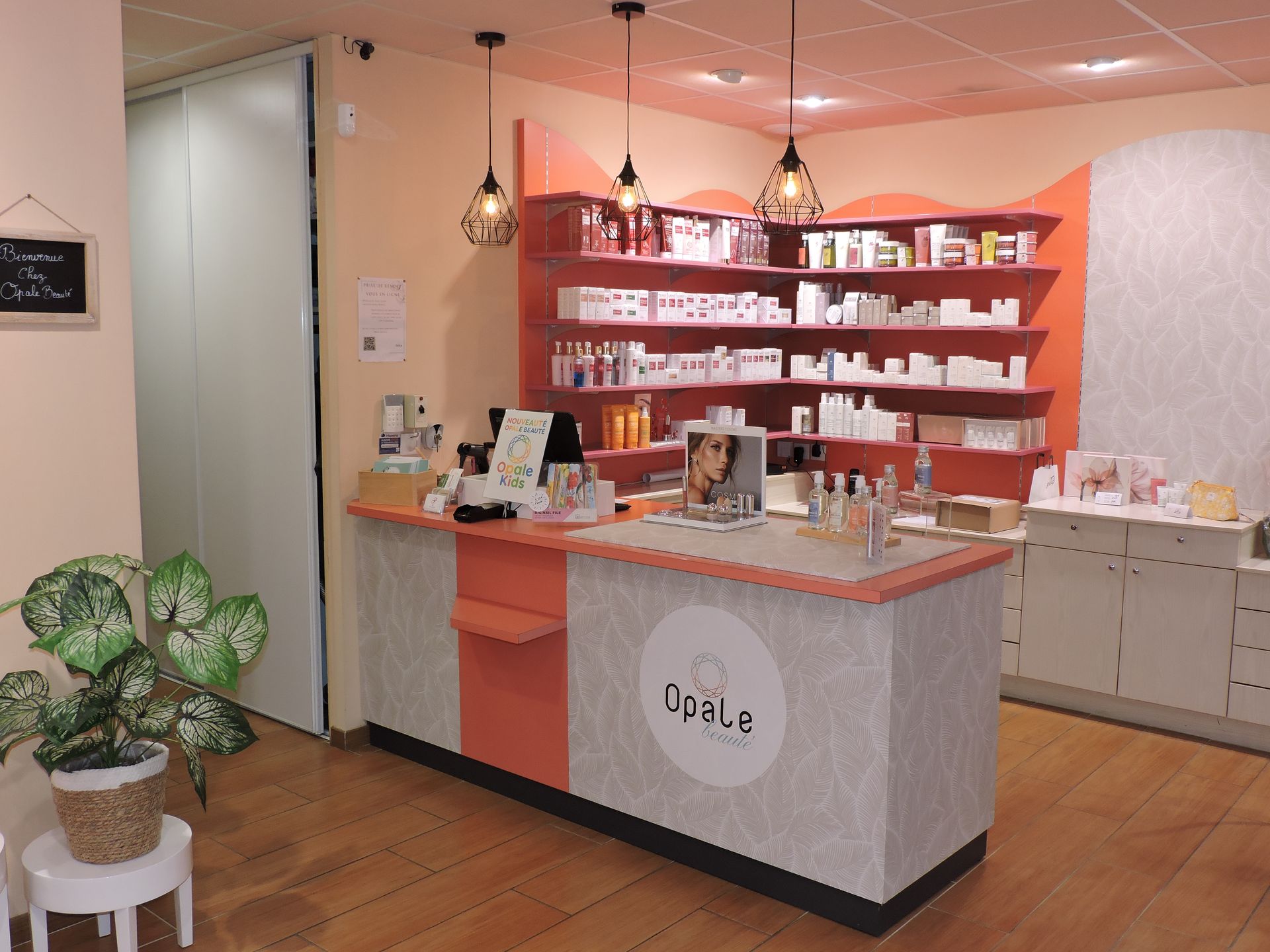 Un comptoir de pharmacie avec des produits sur des étagères et trois lampes suspendues.