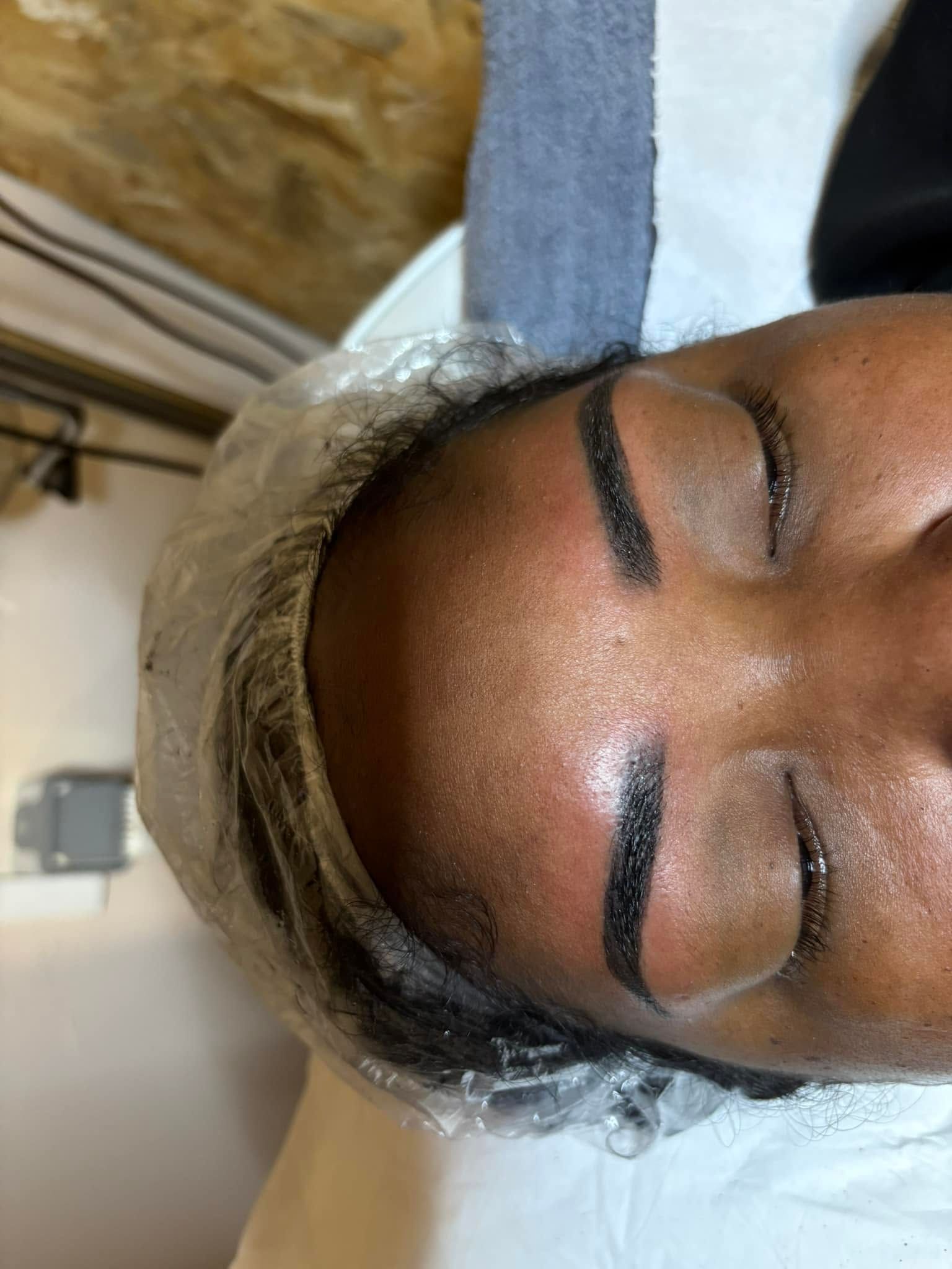 Gros plan sur une personne aux yeux fermés, avec les sourcils dessinés et épilés