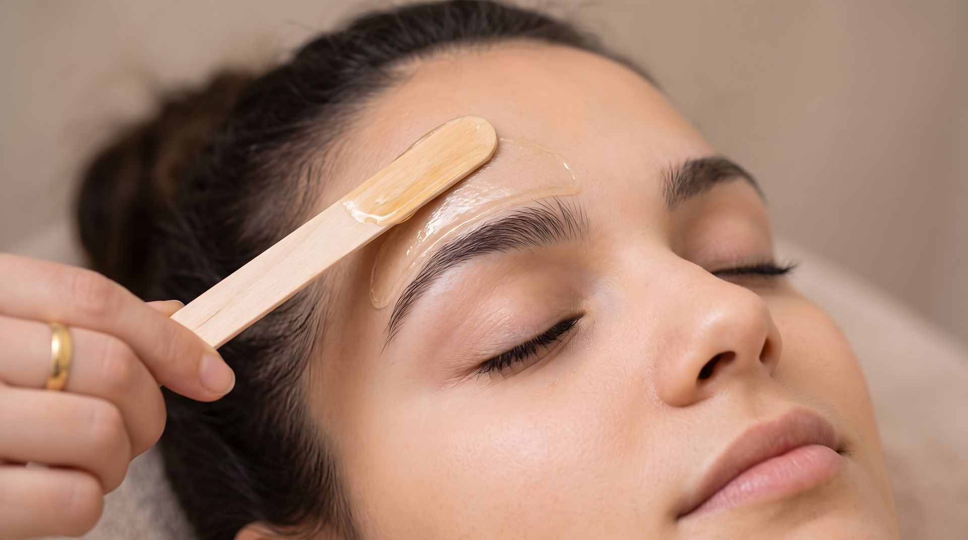 Femme avec bande de cire appliquée au dessus du sourcil