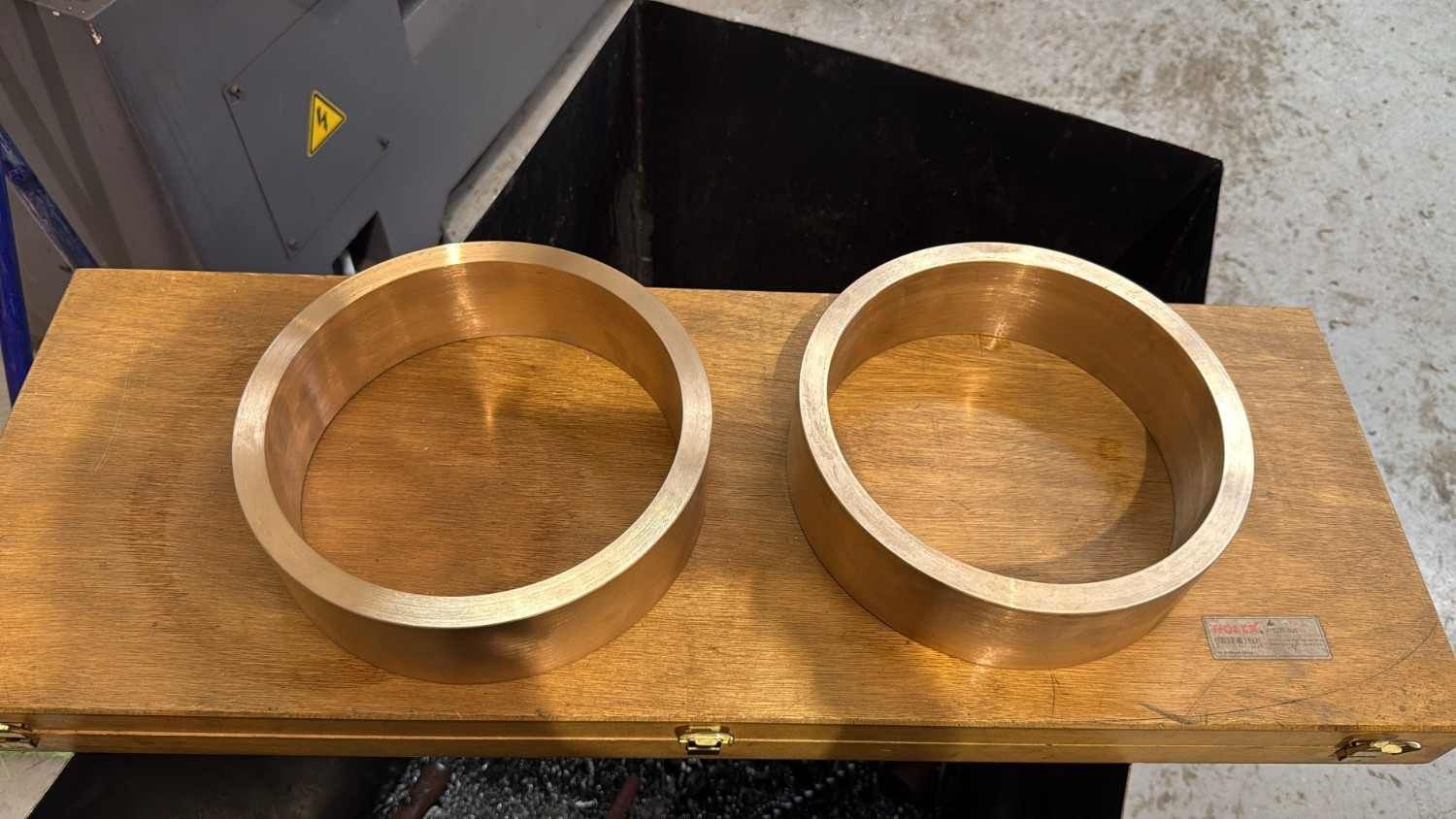 Dos cuencos de bronce sobre una tabla de madera en un taller