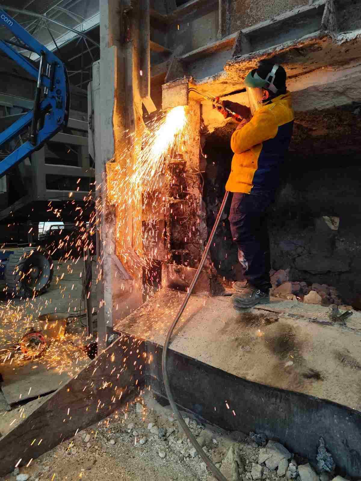 Operario cortando metal con chispas en un taller industrial