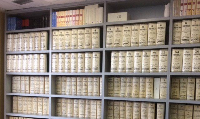 Una biblioteca llena de muchos libros y carpetas