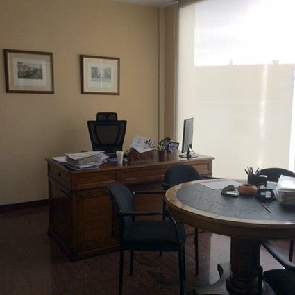 Una habitación con un escritorio, sillas y una computadora.