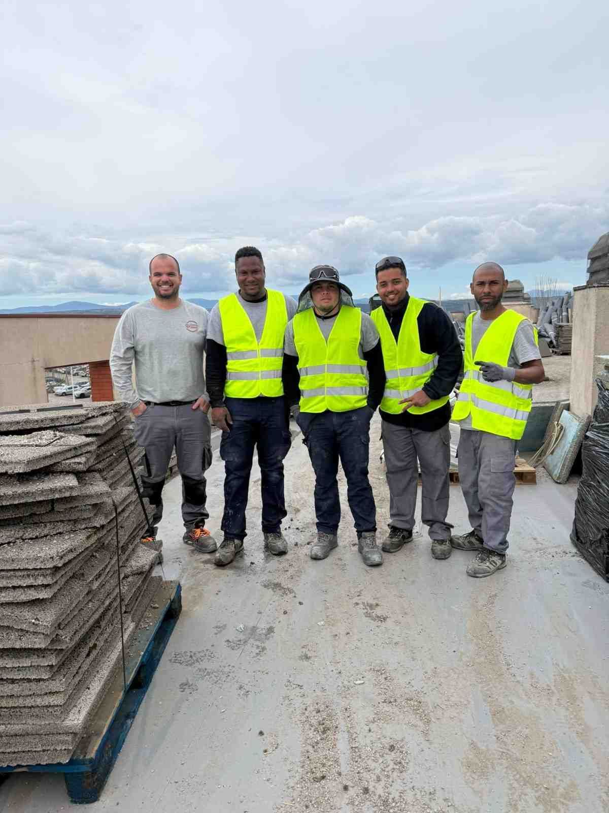 Cinco trabajadores con chalecos reflectantes de color