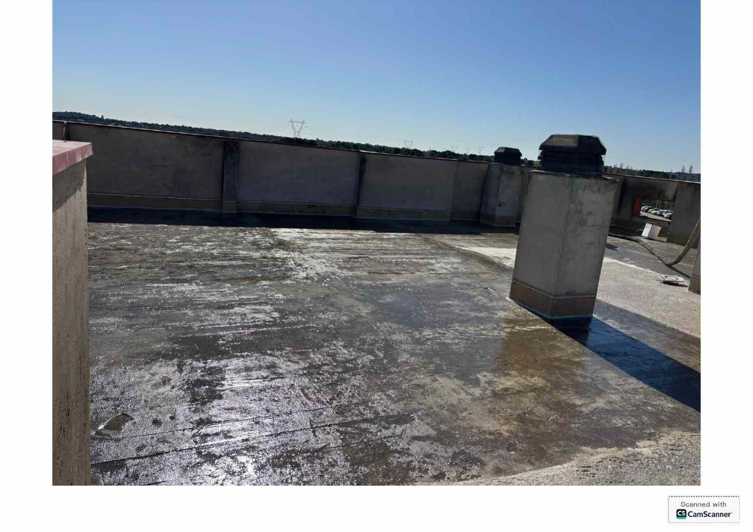 Azotea con una superficie de hormigón desgastada y muros bajos en el perímetro, bajo un cielo azul despejado.