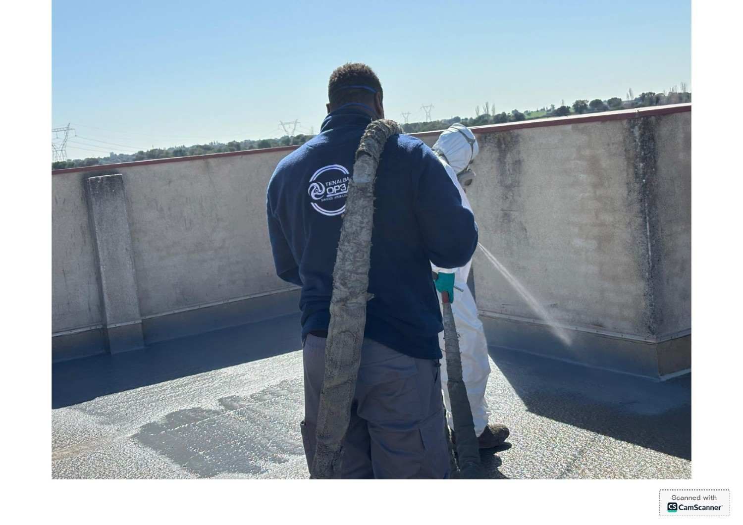 Persona sosteniendo una serpiente grande en una azotea a pleno sol
