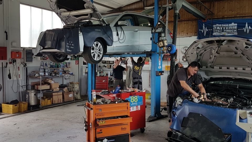 Blick in die Autowerkstatt – eine Auto auf der Hebebühne