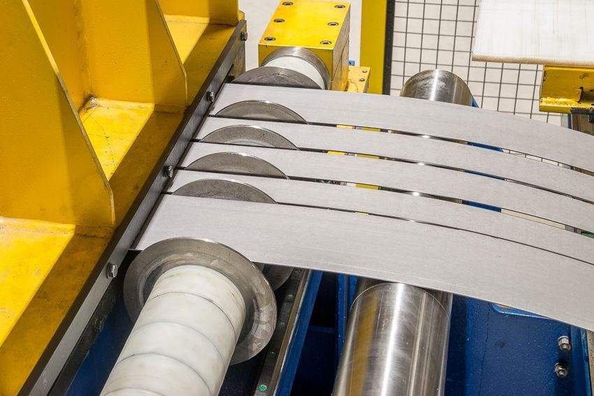 In einer Fabrik schneidet eine Maschine ein Stück Metall.