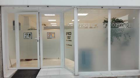 Un edificio blanco con muchas ventanas y una puerta.