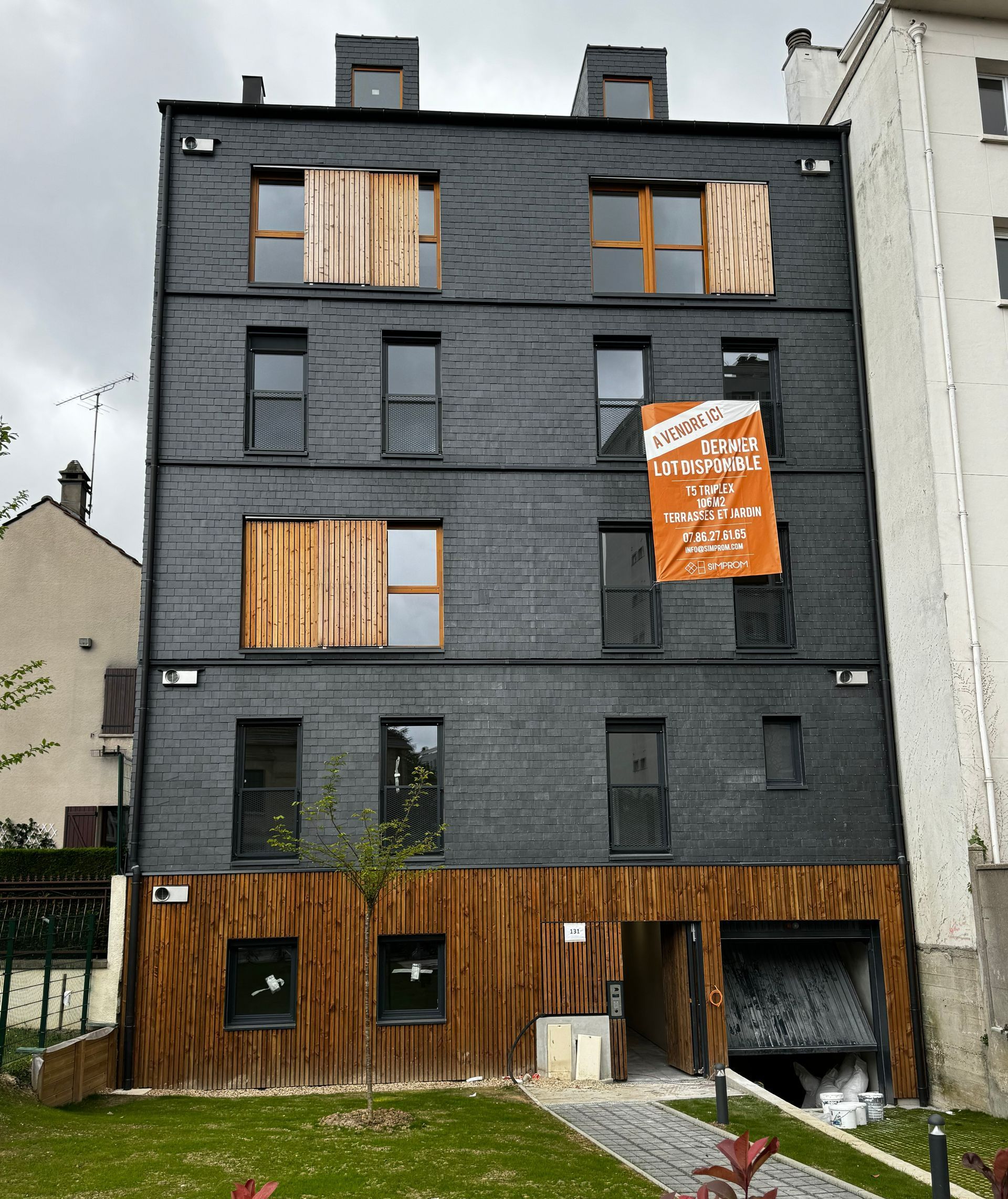 Un bâtiment noir avec une affiche orange