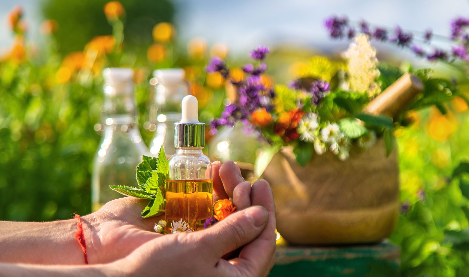 Une main qui tient une petite bouteille contenant de l'huile