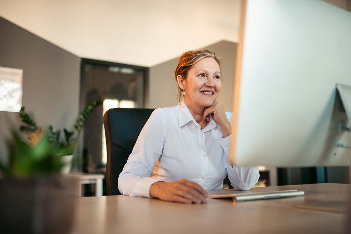 Une dame dans son bureau est en train de regarder l'écran de son ordinateur