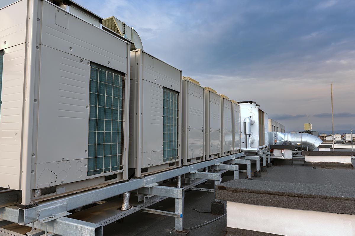 Plusieurs climatisations VRF posées sur une structure en  metallique sont alignés sur le toit d'un bâtiment