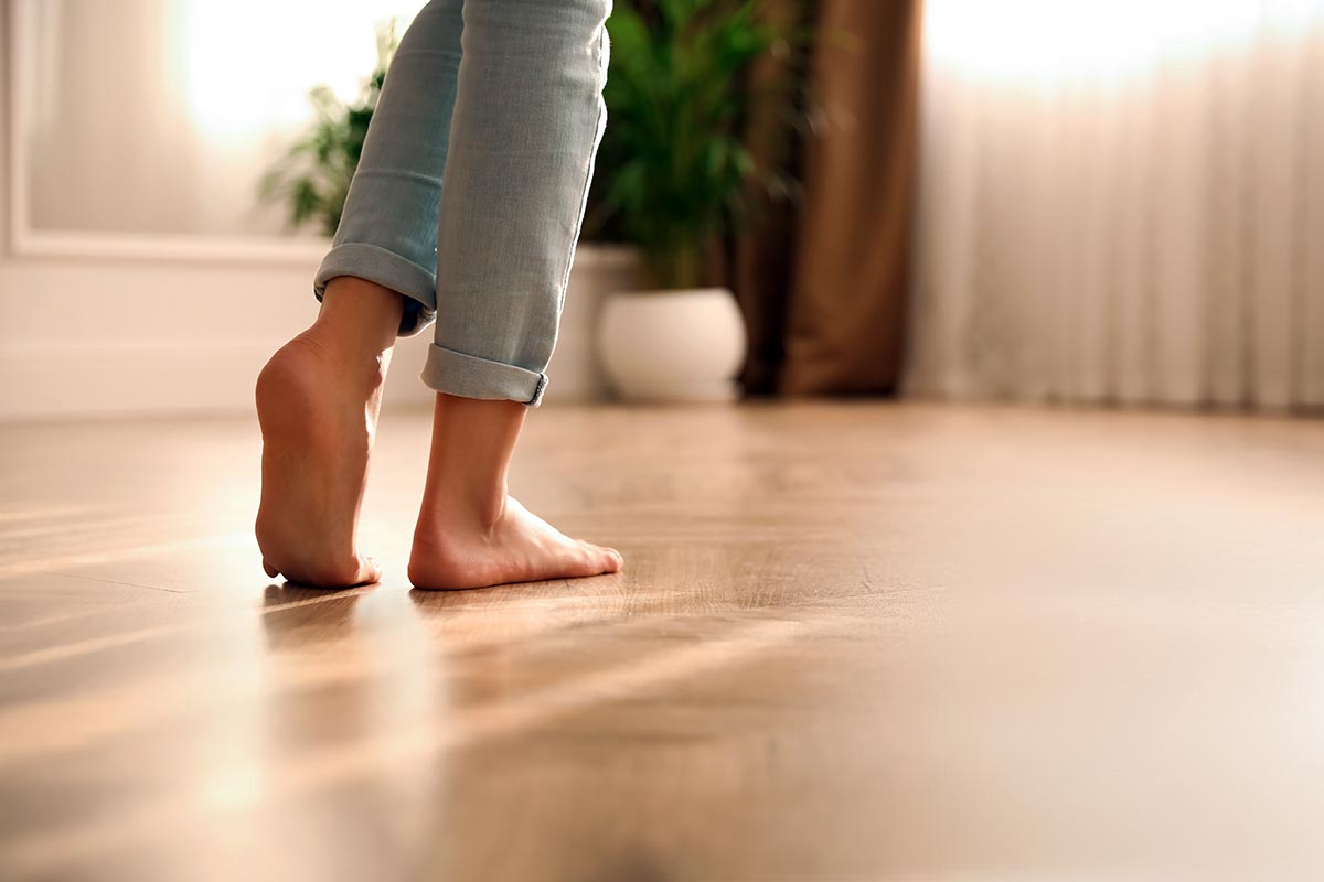 Une personne marche pieds nus sur le plancher d'une pièce de séjour