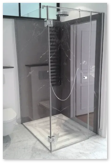 Paroi vitrée d'une cabine de douche d'une salle de bains blanche et grise