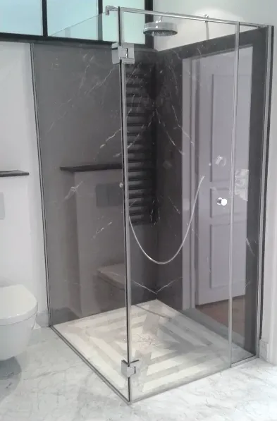 Paroi vitrée d'une cabine de douche d'une salle de bains blanche et grise