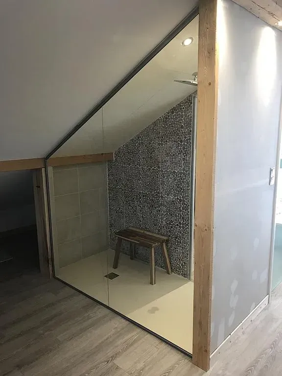 Paroi de douche vitrée sous des combles