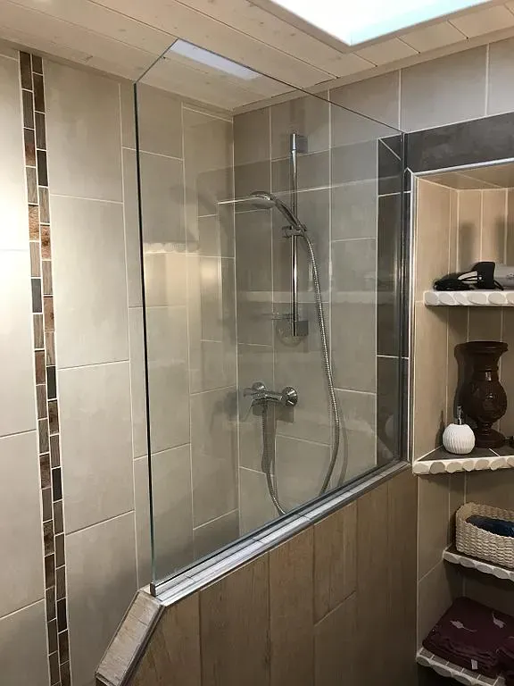 Paroi de douche vitrée à mi-hauteur d'une salle de bains grise