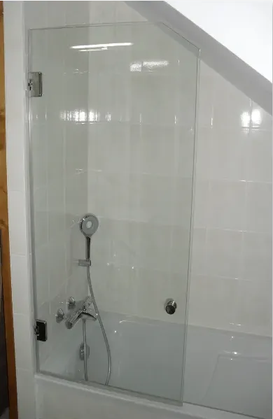 Porte vitrée d'une baignoire sous des combles