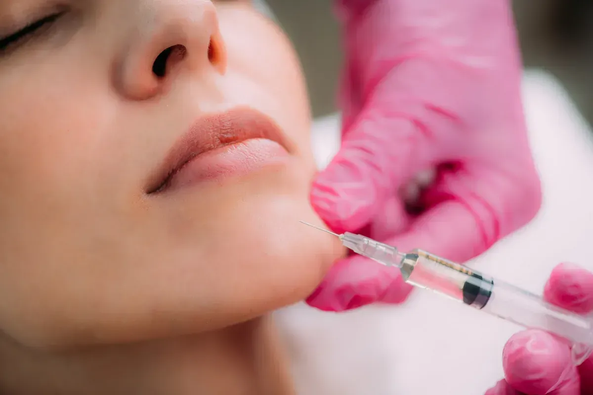 Una mujer recibe una inyección de botox en el mentón.
