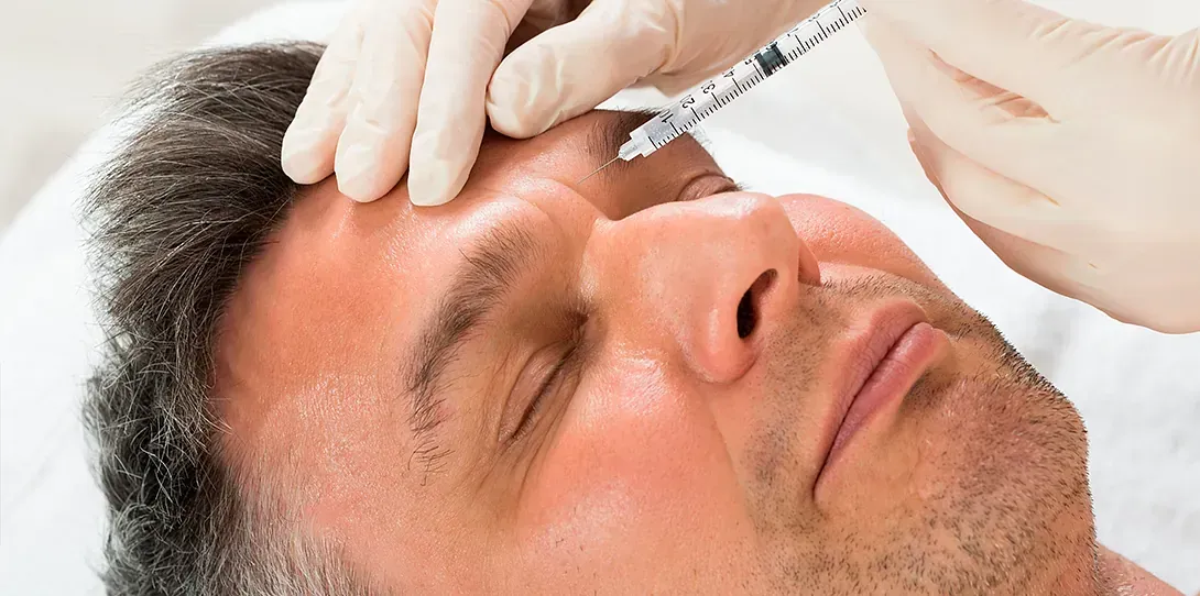 Un hombre recibe una inyección de botox en la frente.