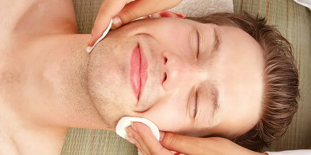 Un hombre está recibiendo un tratamiento facial en un spa.