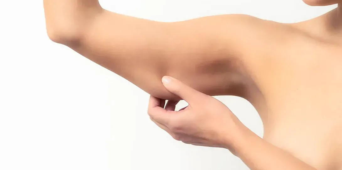 Una mujer se toca el brazo con el dedo.