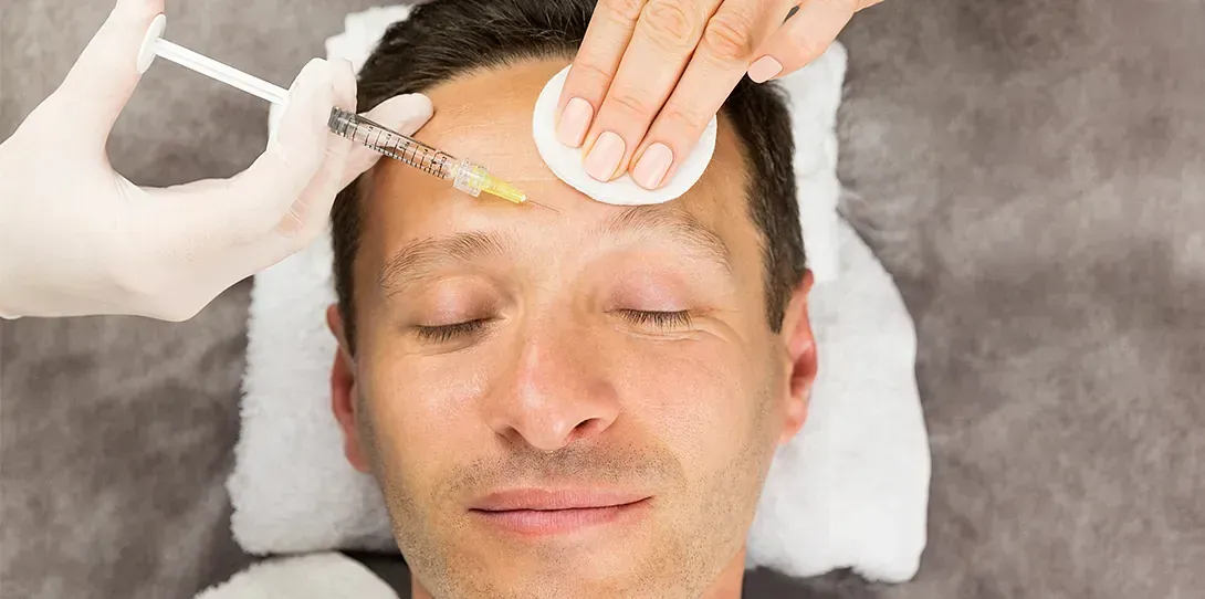 Un hombre recibe una inyección de botox en la frente.