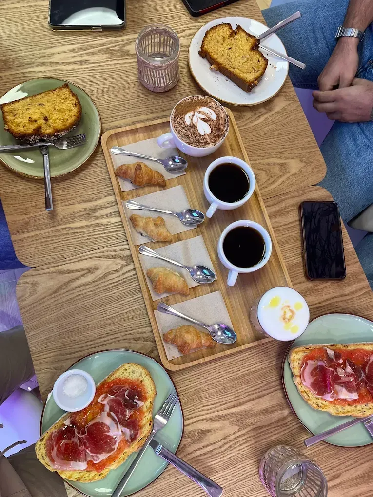Una mesa cubierta con platos de comida y tazas de café.