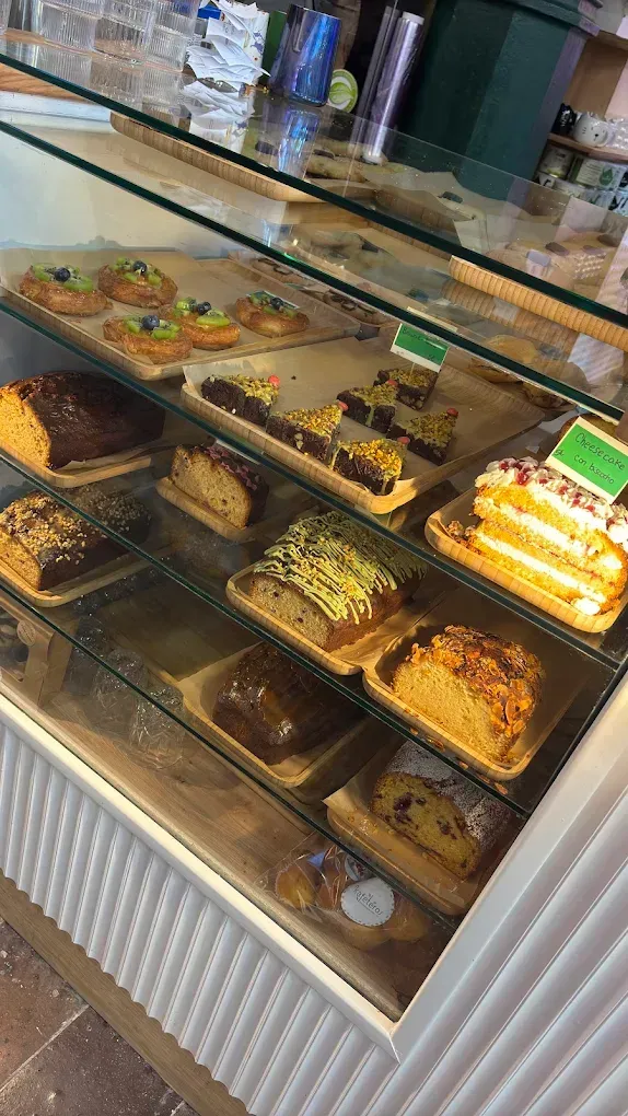 Una vitrina llena de gran cantidad de pasteles y tartas en una panadería.