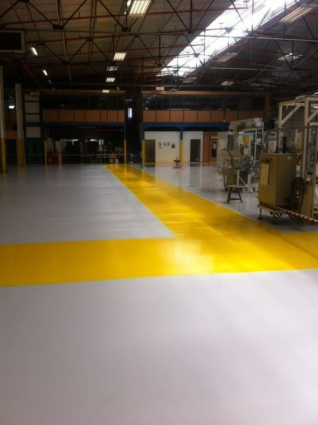Un sol industriel avec une bande jaune en angle droit