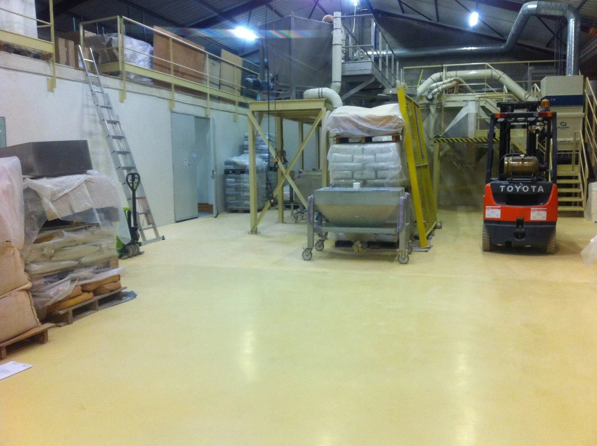 Un entrepôt avec une échelle et des palettes