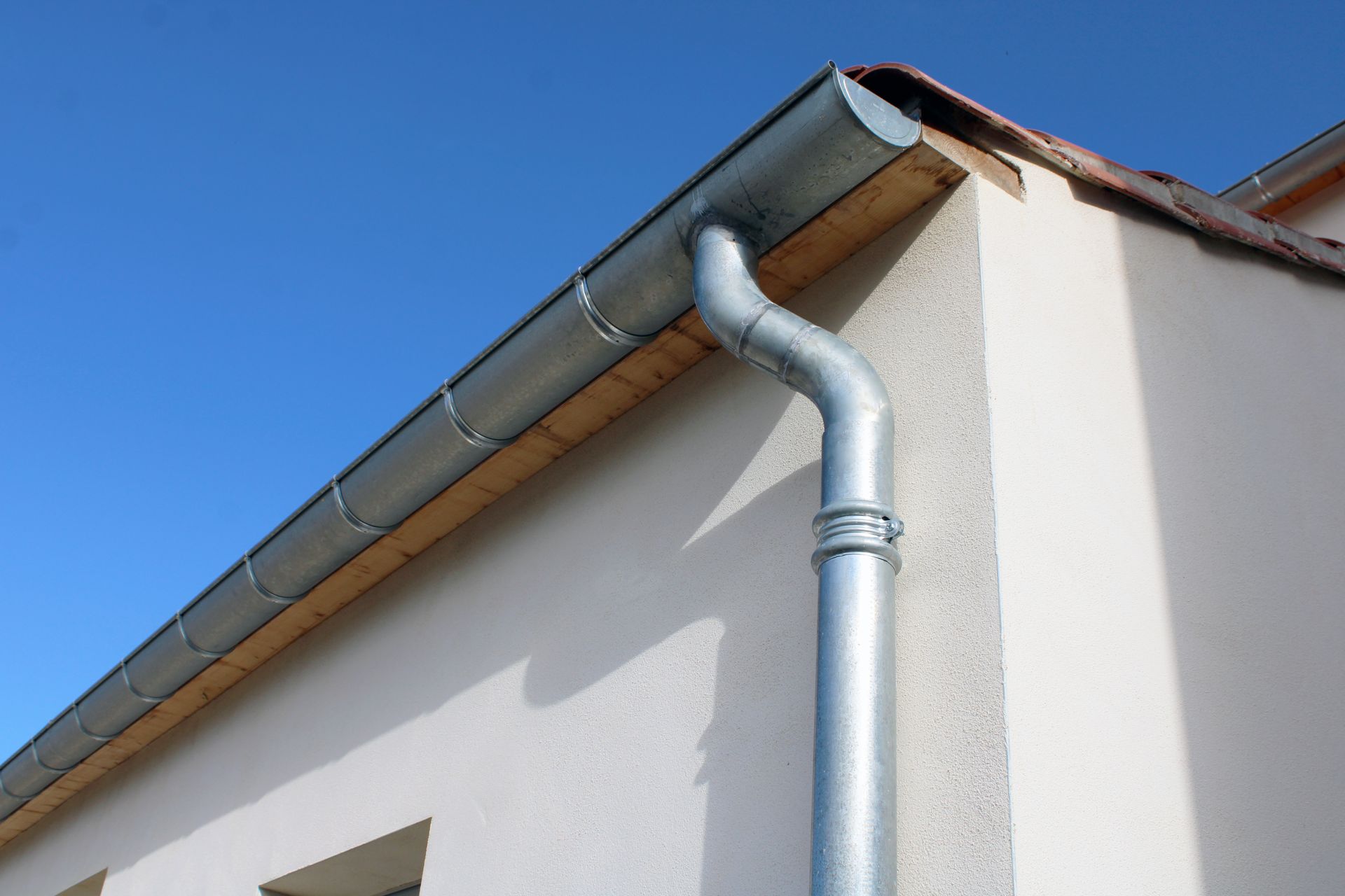 Une gouttière en zinc sur la façade de la maison neuve