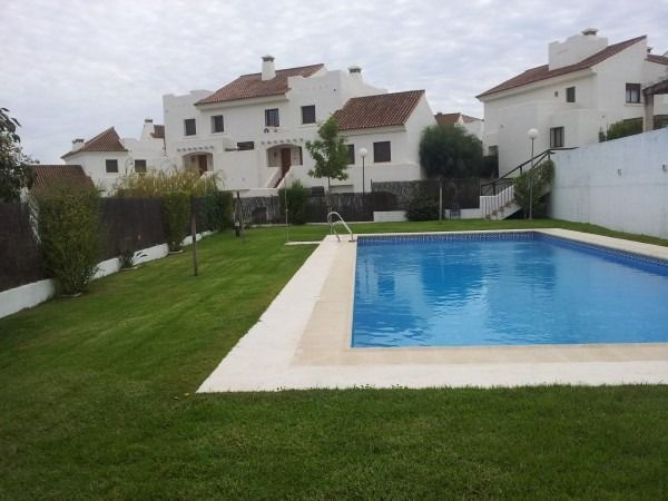 Una gran piscina en medio de un exuberante patio verde.