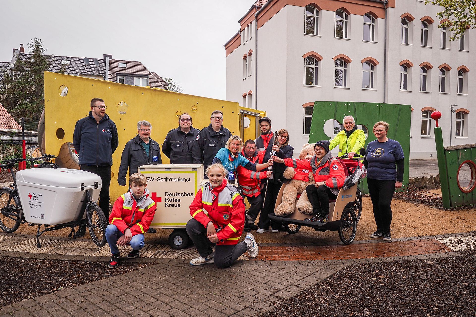 Eine Gruppe von Menschen posiert vor einem Gebäude für ein Foto.