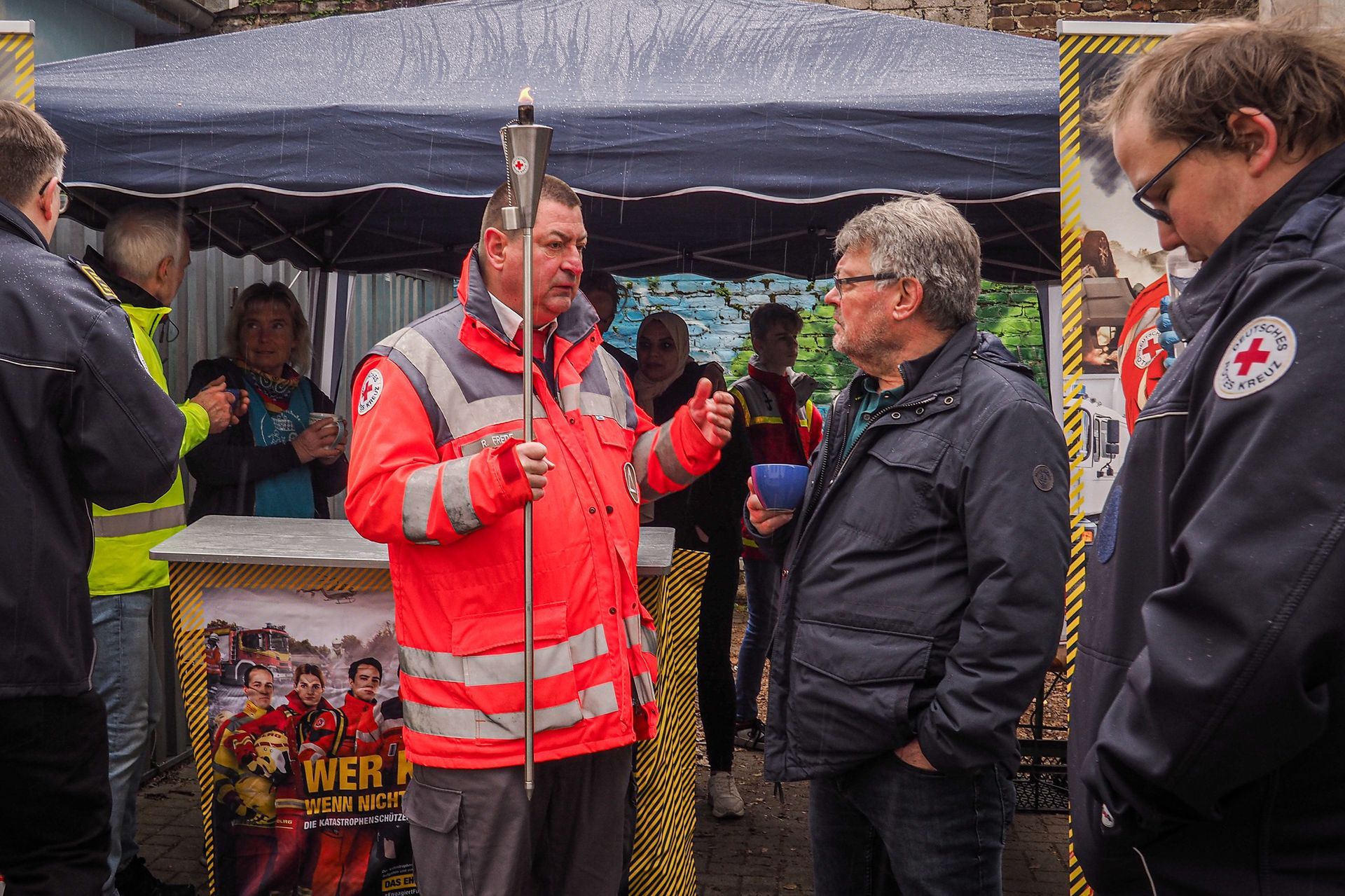 Eine Gruppe von Männern steht um ein Zelt herum und unterhält sich.