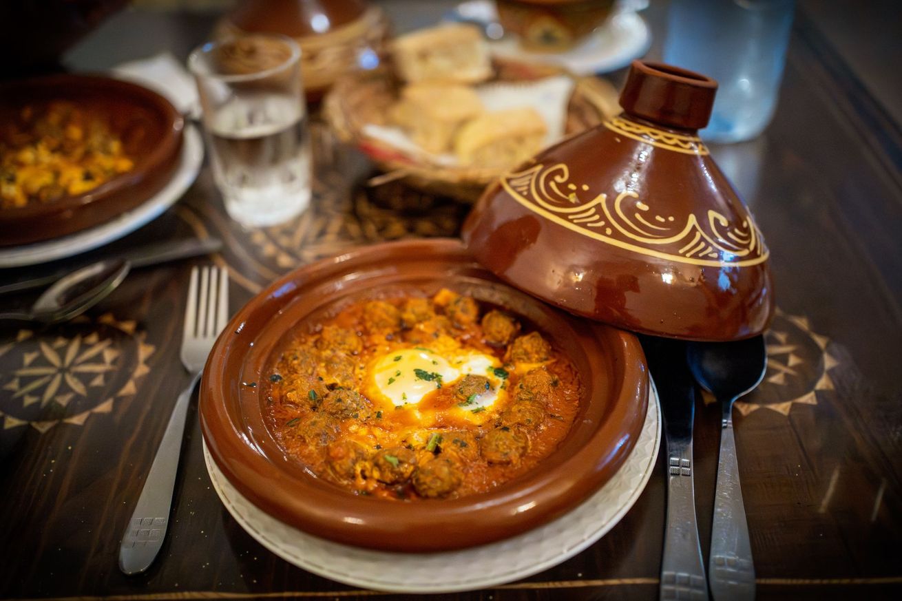 Tajine marocain servi dans un pot en terre cuite sur une table de restaurant