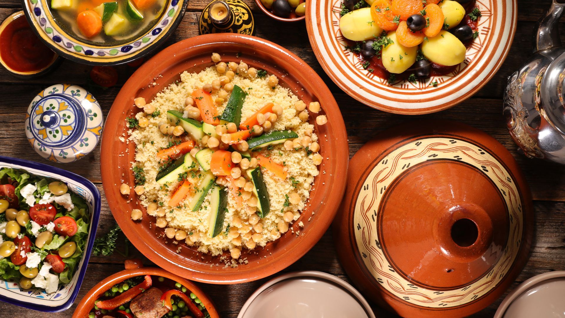 Vue aérienne de tajines et de salades marocaines colorées disposées sur une table